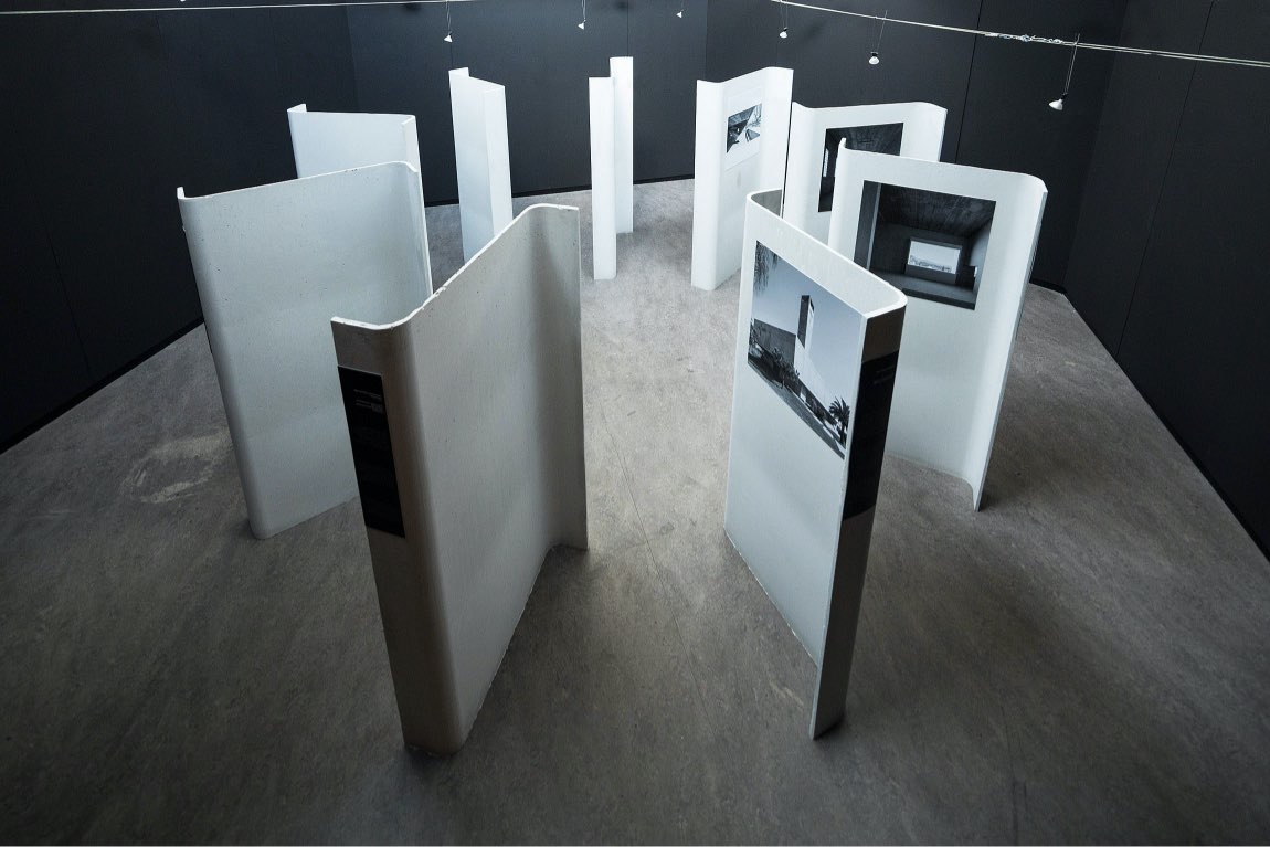 Imagen de la exposición de Elisa Valero con paneles expositivos dispuestos en espiral y fotos