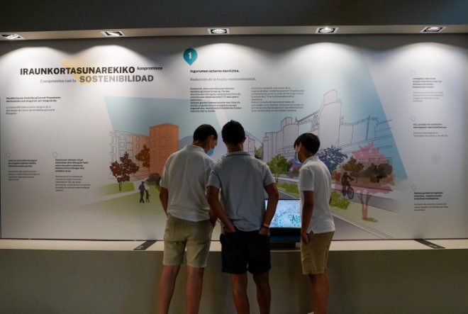 Tres jóvenes interactuando con un panel de la exposición permanente del museo cemento rezola